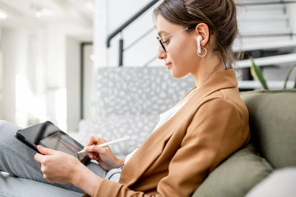 Mujer dibujando en una tableta digital, trabajando desde casa — Foto de Stock