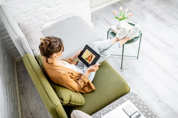 Mujer dibujando en una tableta digital, trabajando desde casa — Foto de Stock