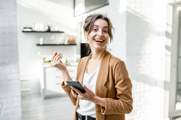 Mulher de negócios com telefone inteligente em casa — Fotografia de Stock