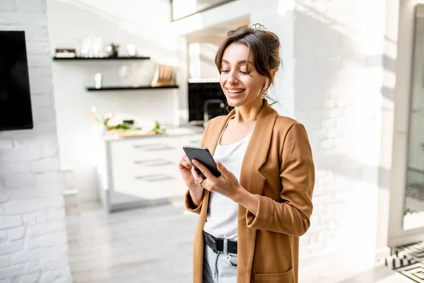 Mujer de negocios con teléfono inteligente en casa — Foto de Stock