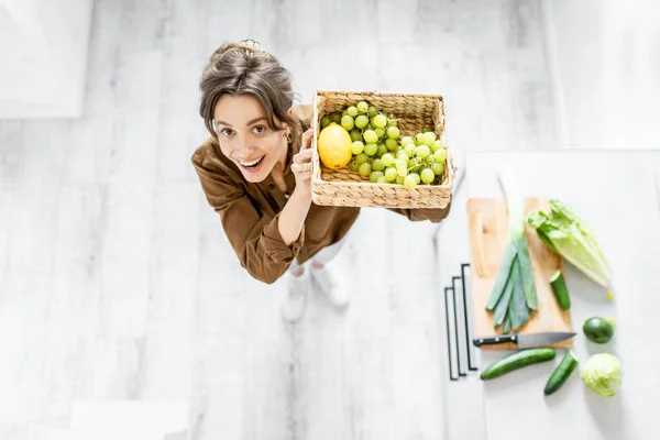 Mujer con comida saludable en la cocina en casa, vista desde arriba —  Fotos de Stock