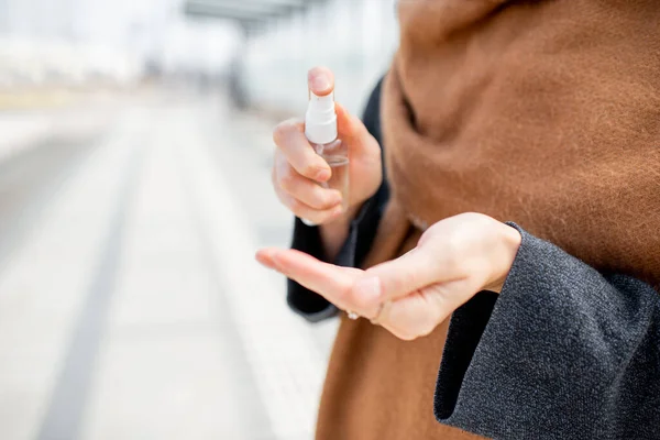 Mujer rociando antiséptico en las manos al aire libre —  Fotos de Stock