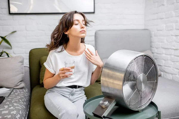 Mujer enfriándose con un ventilador en casa — Foto de Stock