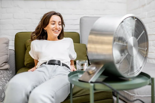 Mujer enfriándose con un ventilador en casa — Foto de Stock