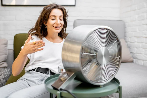 Mujer enfriándose con un ventilador en casa — Foto de Stock