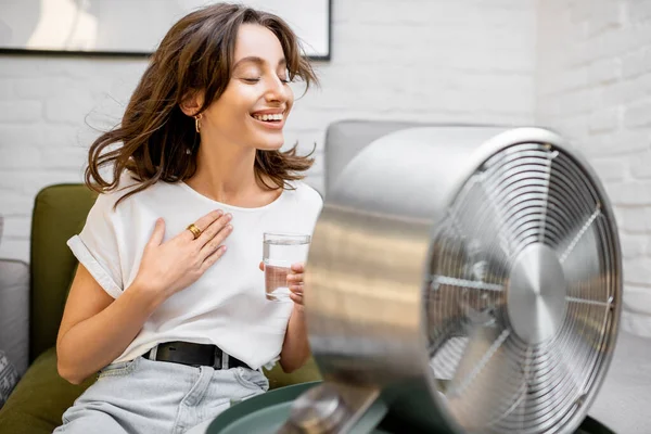 Mujer enfriándose con un ventilador en casa — Foto de Stock