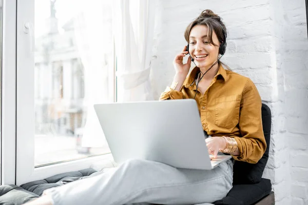 Femme travaillant en ligne sur le rebord de la fenêtre — Photo