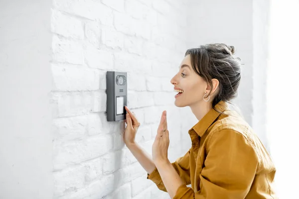 Frau klingelt an der Sprechanlage des Hauses — Stockfoto