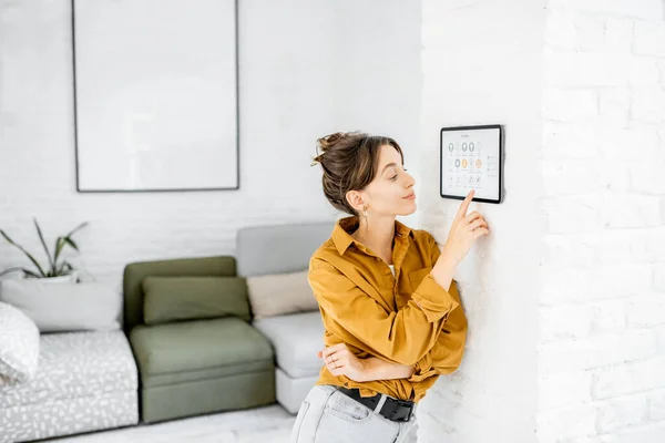 Женщина управляет домом с цифровым сенсорным экраном — стоковое фото