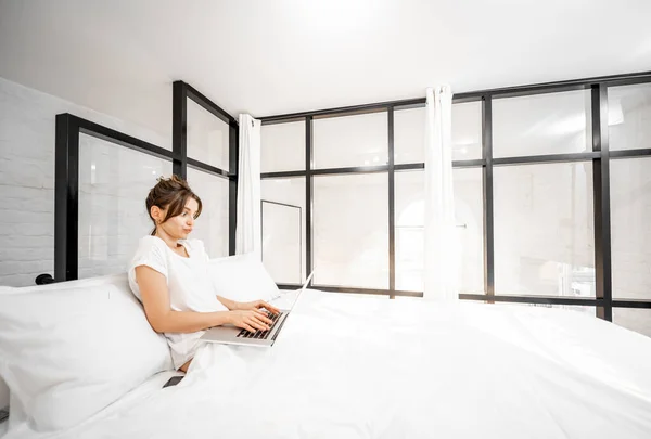 Frau mit Laptop im Schlafzimmer — Stockfoto