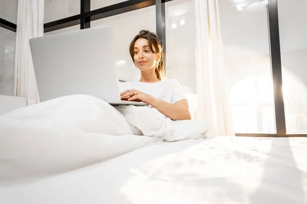 Frau mit Laptop im Schlafzimmer — Stockfoto