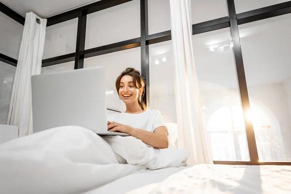 Frau mit Laptop im Schlafzimmer — Stockfoto