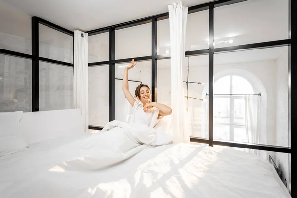 Mujer despertando en el dormitorio soleado — Foto de Stock