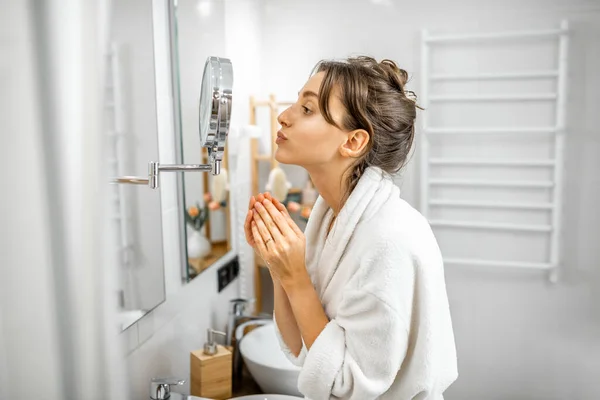 Mujer mirando en su piel en el baño — Foto de Stock