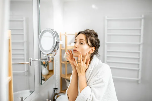 Mujer mirando en su piel en el baño — Foto de Stock