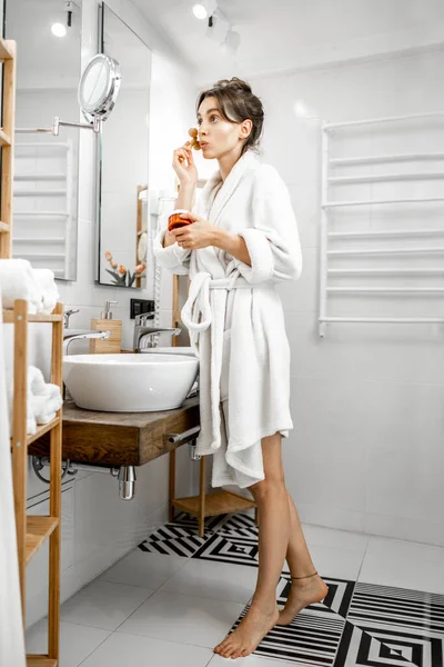 Mujer haciendo masaje facial en el baño —  Fotos de Stock