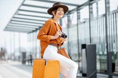 Nakliye durağında bagajı olan genç bir bayan yolcu.