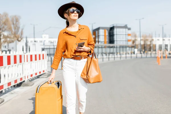 Femme avec une valise dans la rue de la ville — Photo