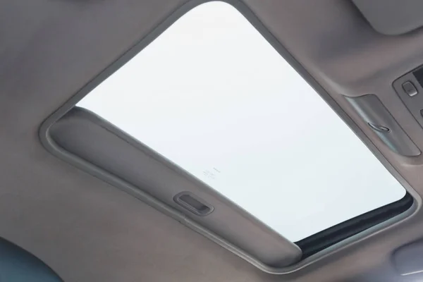 Automotive sunroof close up, white ceiling