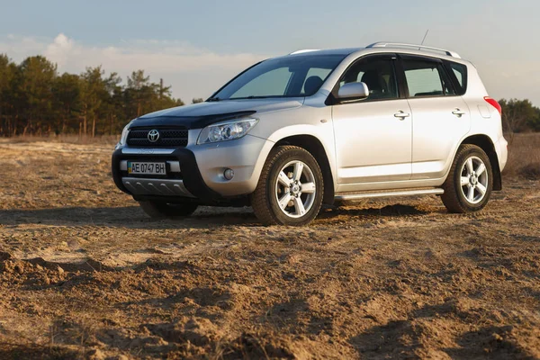 DNIPRO, UKRAINE - FEBRUARY 19, 2020: TOYOTA RAV4 2006 GRAY COLOR AMONG THE SAND NEAR THE FOREST, OPEN SPACE ON SUNSET