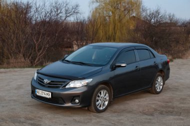 Oleksandrivka, Dnipropetrovsk bölgesi, Ukrayna - 10 Mart 2020: Toyota Corolla alacakaranlıktaki Samara nehir kıyısında gri renk