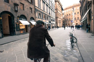 FLORENCE, İtalya - 13 Mart 2018: Floransa, İtalya 'da Santa Trinita meydanına yakın bisiklet süren yaşlı bir adamın geniş açılı fotoğrafı