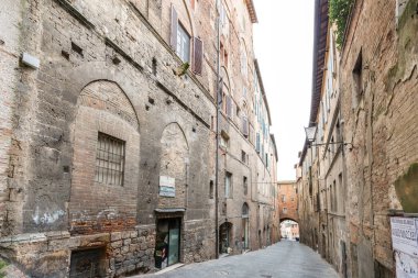 SIENA, İtalya - 13 Mart 2018: Siena, İtalya 'nın ortaçağ bölgesindeki eski ve dar bir caddenin yatay resmi