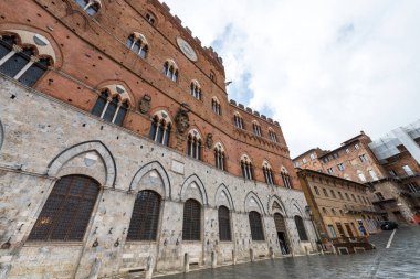 SIENA, İtalya - 13 Mart 2018: Siena, İtalya 'nın ana manzarası olan Piazza del Campo' daki Torre del Mangia 'nın büyük duvarlarının geniş açı resmi