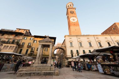 VERONA, ITALY - 14 Mart 2018: Lamberti kulesinin yatay resmi ve günbatımı sırasında İtalya 'nın Verona kentinde bulunan Piazza Delle Erbe' deki eski pazar