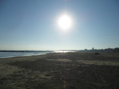 Güneşin zirvesinde boş sahil ve denizin görüntüsü