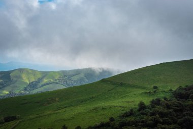 Yeşil çimenli dağ ve güzel gökyüzü görüntüsü doğanın inanılmaz güzelliğini ve sanatını gösteriyor. Bu görüntü Karnataka Hindistan 'da tepeden çekildi..