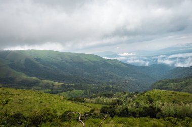 Bulut katmanları ve güzel gökyüzü görüntüleriyle kaplı dağ, doğanın inanılmaz güzelliğini ve sanatını gösteriyor. Bu görüntü Karnataka Hindistan 'da tepeden çekildi..