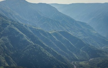 Beyaz sisle kaplı sisli dağ sırası ve muhteşem mavi gökyüzü görüntüsü tepenin güzel doğal manzarasını gösteriyor. Görüntü Latilum Peak Shillong Meghalaya Hindistan 'da çekilmiştir..