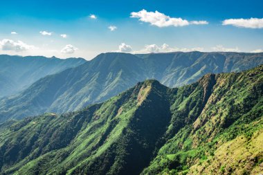 Beyaz sisle kaplı sisli dağ sırası ve muhteşem mavi gökyüzü görüntüsü tepenin güzel doğal manzarasını gösteriyor. Görüntü Latilum Peak Shillong Meghalaya Hindistan 'da çekilmiştir..