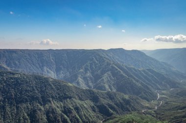 Beyaz sisle kaplı sisli dağ sırası ve muhteşem mavi gökyüzü görüntüsü tepenin güzel doğal manzarasını gösteriyor. Görüntü Latilum Peak Shillong Meghalaya Hindistan 'da çekilmiştir..