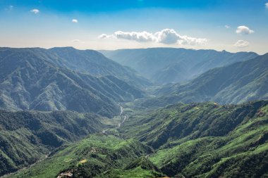Beyaz sisle kaplı sisli dağ sırası ve muhteşem mavi gökyüzü görüntüsü tepenin güzel doğal manzarasını gösteriyor. Görüntü Latilum Peak Shillong Meghalaya Hindistan 'da çekilmiştir..