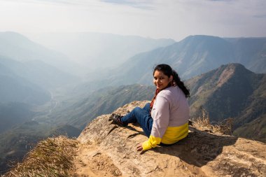 Bu güzel dağ sırasını dağ görüntüsünün kenarından izleyen kız, Hindistan 'daki Laytilum Peak Shillong Meghalaya Tepesi' nden alınmıştır. Burası ayrıca Şillong 'un Büyük Kanyonu olarak da bilinir..