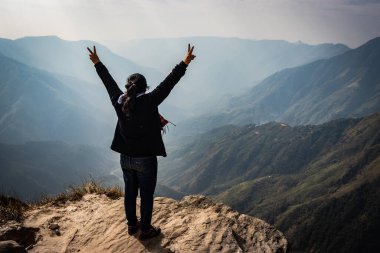 Bu güzel dağ sırasını dağ görüntüsünün kenarından izleyen kız, Hindistan 'daki Laytilum Peak Shillong Meghalaya Tepesi' nden alınmıştır. Burası ayrıca Şillong 'un Büyük Kanyonu olarak da bilinir..