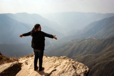 Bu güzel dağ sırasını dağ görüntüsünün kenarından izleyen kız, Hindistan 'daki Laytilum Peak Shillong Meghalaya Tepesi' nden alınmıştır. Burası ayrıca Şillong 'un Büyük Kanyonu olarak da bilinir..