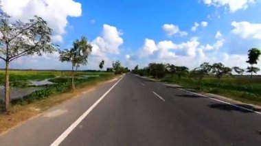 Asfalt klip yolunda motosiklet sürücüsü inanılmaz mavi gökyüzü ve bulut yaması klipsi ile seyahat etmenin güzelliğini gösteren motosiklet sürüşü çekilirken.