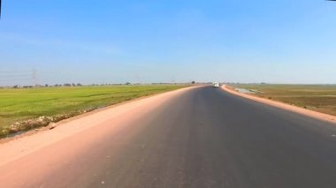 Asfalt klip yolunda motosiklet sürücüsü inanılmaz mavi gökyüzü ve bulut yaması klipsi ile seyahat etmenin güzelliğini gösteren motosiklet sürüşü çekilirken.