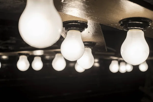 Glühende Lampe auf Holzsockel — Stockfoto