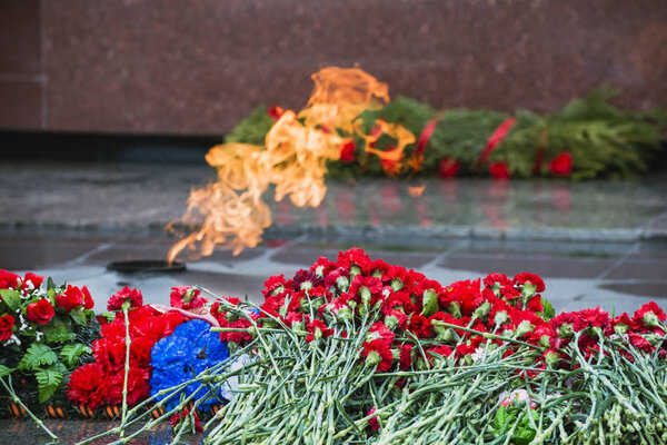 Цветы гвоздики положить на мемориал вечный огонь
