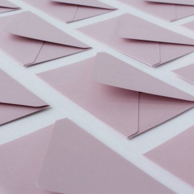 Beyaz arkaplanda parlak turkuaz zarflardan oluşan yaratıcı desen.