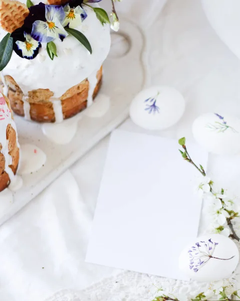 Традиційний великодній панеттон з квітковим прикрасою та білим глазуруванням на білому тлі з білими візерунками яєць та вітальною листівкою на напис . — стокове фото