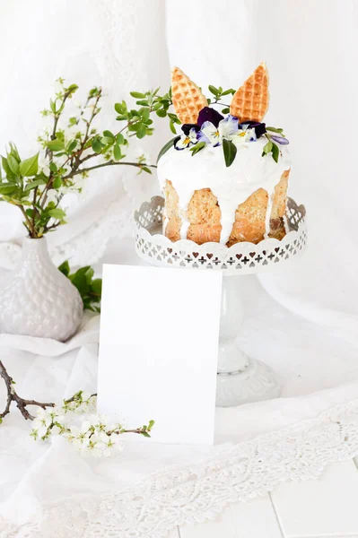 Традиційний великодній панеттон з квітковим прикрасою та білим глазуруванням на білому тлі з білими візерунками яєць та вітальною листівкою на напис . — стокове фото