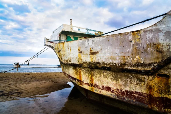 Old rusty boat on a beach.