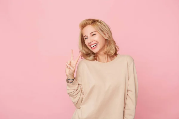 Radostné Blond Žena Stojící Nad Růžové Pozadí Usmívá Ukazuje Sign — Stock fotografie