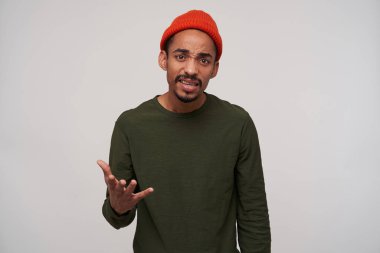 Sinirli, genç, esmer, esmer, sakallı bir adamın stüdyo shor 'u. Kafası karışmış bir şekilde kameraya bakıyor.