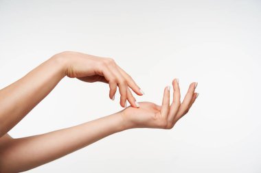 Genç ve çekici bir kadının el kaldırarak parmaklarıyla nazikçe dokunuşunu beyaz arka planda izole edilmiş başka bir el resmi.